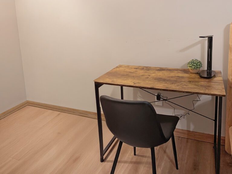 Work space in bedroom #1 with desk, lamp, and comfortable chair